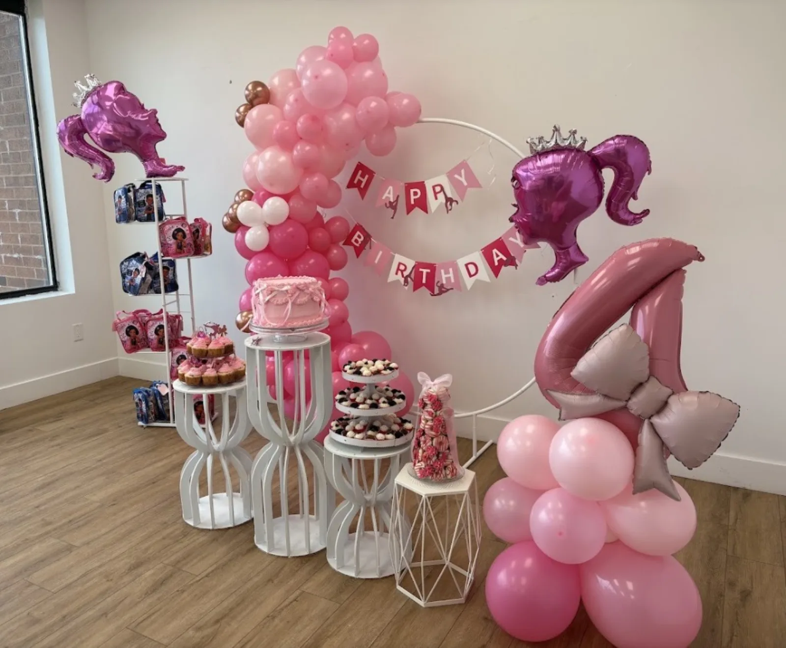 Birthday dessert table with balloon arch and cake at Fun Factory
