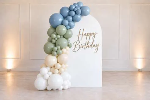 Single backdrop with organic balloon garland and Happy Birthday neon sign